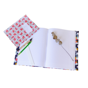 Cahier au format A4 de la marque Cabanon avec couverture colorée, accompagné de crayons et d'une branche de baies séchées. Produit artisanal et responsable, parfait pour l’école ou le bureau | commercialisé par la boutique Tipi à Theux