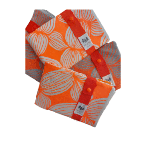 Pochettes textiles colorées Pet-O-Sec avec motif de feuilles, bouton orange et bande rouge. Réutilisables, cousues localement, zéro plastique | commercialisé par la boutique Tipi à Theux