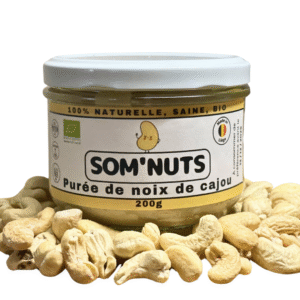 Bocal purée noix de cajou bio Som’Nuts posé sur noix de cajou. Texture riche, sans additifs, fabrication locale | commercialisé par la boutique Tipi à Theux