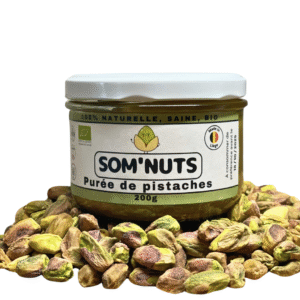 Purée pistaches bio Som’Nuts, pot sur lit de pistaches. 100 % naturelle, sans sucre ajouté, texture onctueuse | commercialisé par la boutique Tipi à Theux